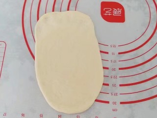 果酱奶酥排包,取一份醒好的小面团先擀成椭圆形，末端压薄然后卷起来，稍稍滚几下让它成长条状；