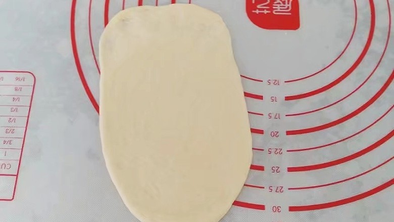 果酱奶酥排包,取一份醒好的小面团先擀成椭圆形，末端压薄然后卷起来，稍稍滚几下让它成长条状；