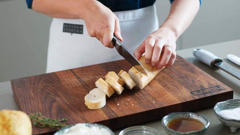 意大利乳清干酪烤面包佐蜂蜜烤梨,将烤箱预热至200度。法棍切片，在铺好烘焙纸的烤盘中摆好。