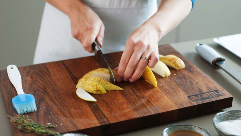 意大利乳清干酪烤面包佐蜂蜜烤梨,将烤箱温度调至220度。梨切片，放到铺好烘焙纸的烤盘上。