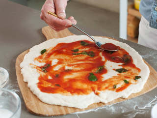 拿波里披萨,在一个小碗中，混合番茄泥、橄榄油和盐。大致撕碎罗勒叶，并将其加到酱汁中。在披萨上涂上薄薄一层酱料。将披萨转放到披萨板上，在预热好的烤箱中，以250度烘烤6-7分钟。