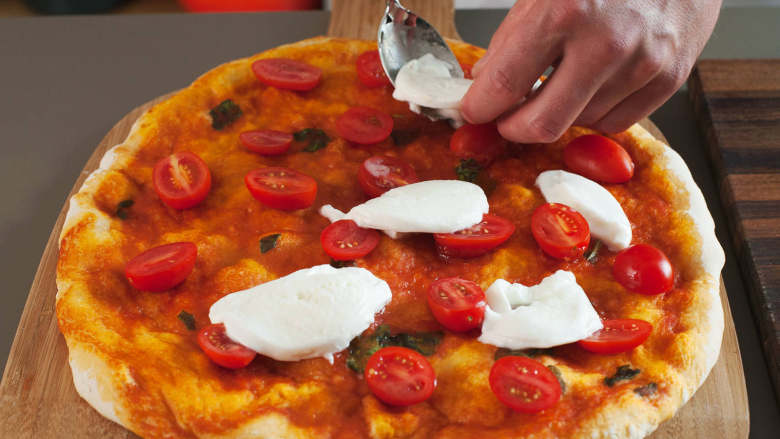 拿波里披萨,与此同时，将<a style='color:red;display:inline-block;' href='/shicai/ 3437'>樱桃番茄</a>切半，水牛奶酪切成薄片。将披萨从烤箱中取出；将番茄和奶酪放在披萨上后，再将其放回烤箱，烤上6-7分钟，直至芝士融化，而面皮变得金黄。