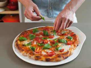 拿波里披萨,在披萨上撒上罗勒叶装饰。若喜欢，可在享用前再淋上点橄榄油。享用吧!