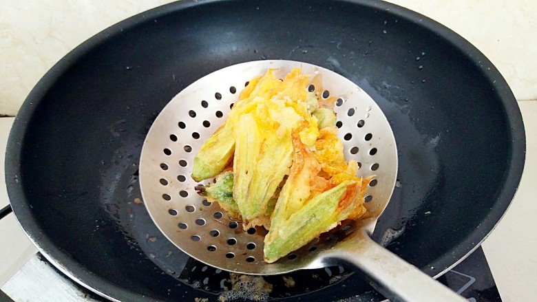 香酥南瓜花,炸到半软半酥，捞出控油，开始重新烧热油锅。