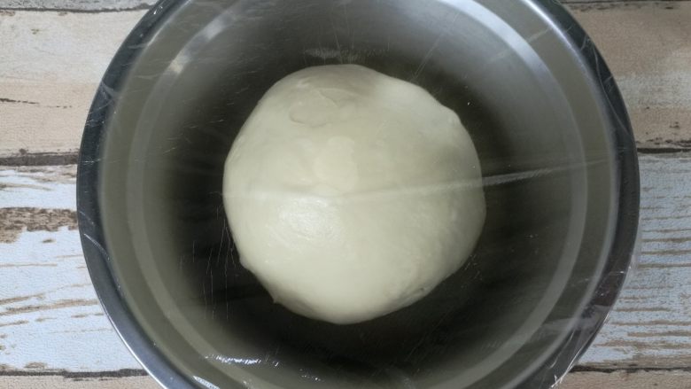 超好吃奶黄餐包,面团收圆，放盆内该保鲜膜进行基础发酵。