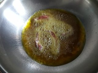 糖醋牛肉里脊,油热后，将里脊条一根一根地放入油锅中煎炸，炸好后盛出备用。
