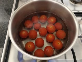 西红柿和梅子的相遇,取一个小锅，先把水烧开，再把西红柿沥干加进来，煮至1-2分钟，当西红柿爆皮时关火，