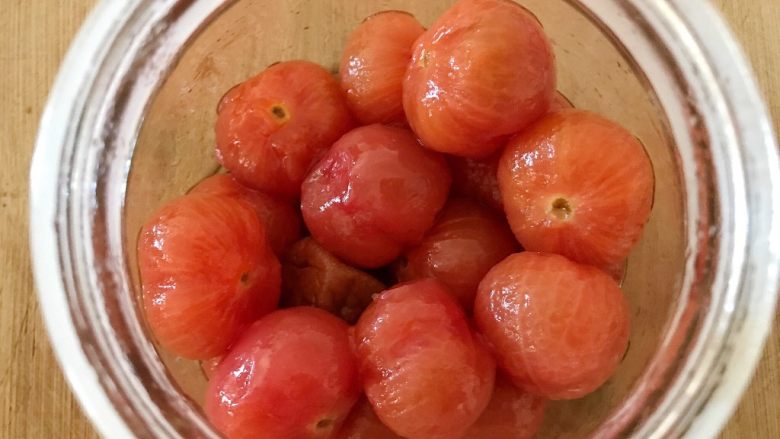 西红柿和梅子的相遇,接下来，我们把刚才剥好的小番茄装入罐子中（盘子或者碗都可以），