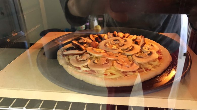 蘑菇披薩,將烤盤放入預熱好上下火250度的烤箱內，烘烤5～10分鐘，至奶酪全部融化有些變黃，餅邊兒也微微泛黃就烤熟了