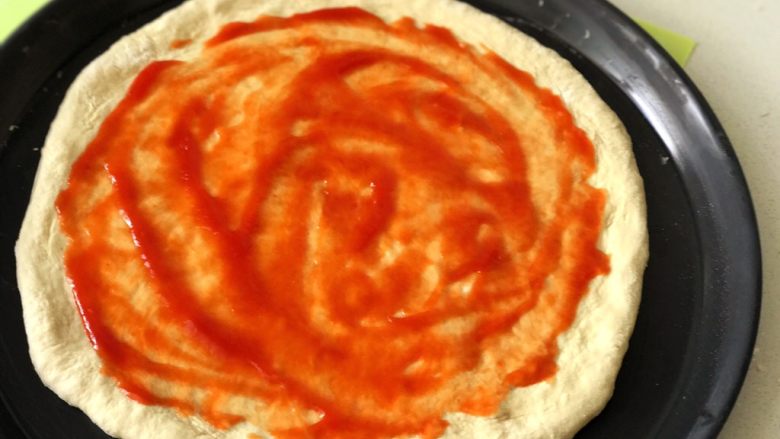 蘑菇披薩,然後用勺子挖兩勺去皮整番茄罐頭打碎的番茄泥，塗抹均勻但不要塗在餅邊上