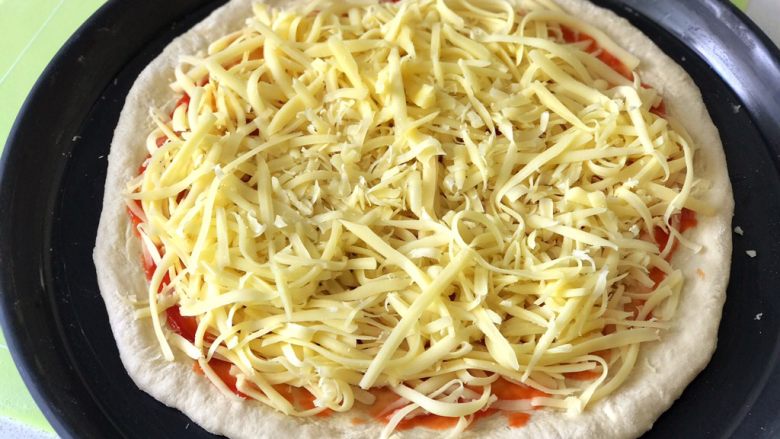 蘑菇披薩,將奶酪絲均勻的碼在上面（注意用量，過多呢烤的時候容易流出來，過少呢又不香😋）