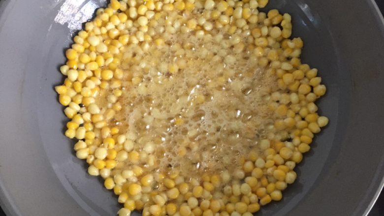黄金玉米烙,此时把刚才烧热倒在碗里的油倒入锅里，油要没过玉米粒，转中火炸玉米粒至金黄酥脆即可。
