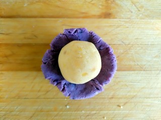 甜心三色糯米雪绒球,取一份紫薯球捏扁放入步骤14的红薯球用虎口收紧滚圆（其它份照做）