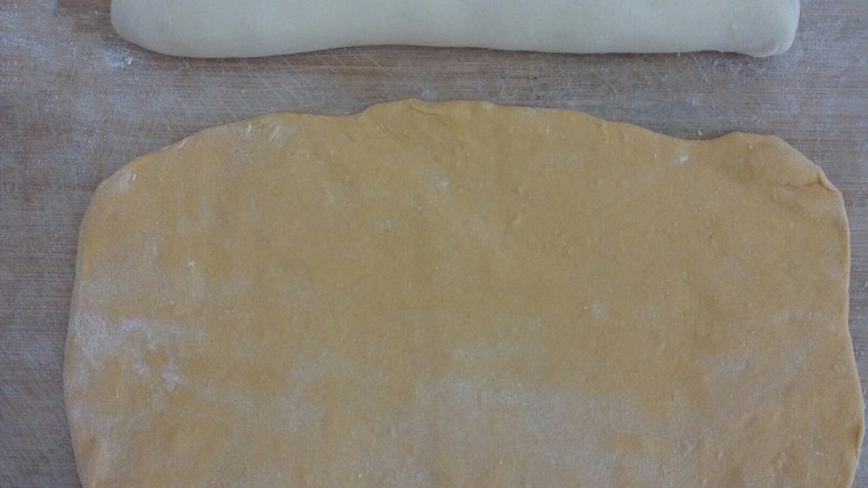 南瓜包子,﻿﻿刀板上撒些面粉，﻿把白面揉成长条﻿﻿﻿﻿，把南瓜面团擀成长方形﻿﻿﻿﻿