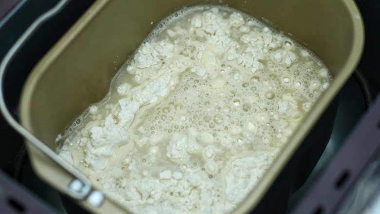 东北猪肉酸菜馅包子,将酵母水和剩下的温水一同倒入面粉中