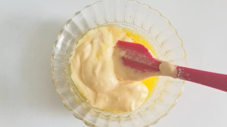 果味长崎纸杯蛋糕,取少许蛋糊放入黄油牛奶混合液中翻拌均匀；