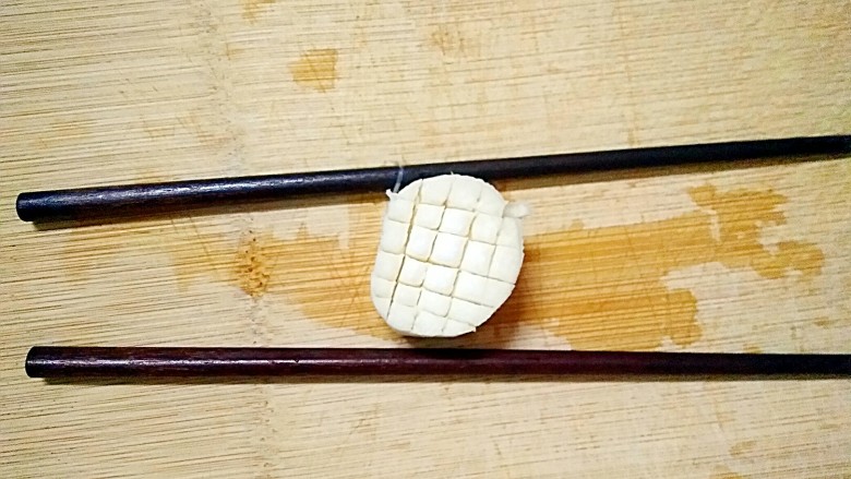 花样杏鲍菇,把一小块杏鲍菇交叉切成小格子，两侧放上两根筷子，筷子的作用防止的杏鲍菇底部切断了