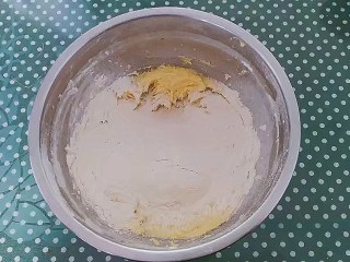 爱心编织饼干,低筋面粉和泡打粉混合筛入黄油里， 先用橡皮刮刀翻拌，使面粉和黄油混合。混合得差不多的时候，用手稍揉成团即可。
