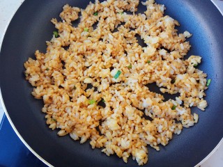 剩米饭妙用—鸡蛋酱油炒饭,锅里再次入油，放入葱花和酱油翻炒