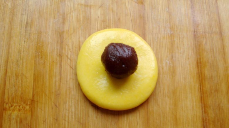 雅韵黄梅,取30克一个的小剂子，团成圆球按扁，放入8克的豆沙馅。