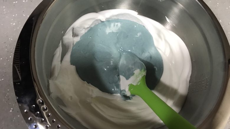 蓝天白云戚风,翻拌均匀的蛋糕糊倒回剩余蛋白霜，翻拌均匀。