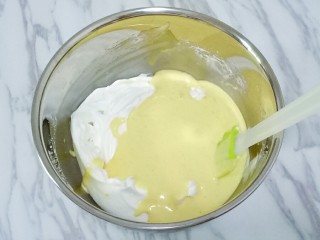 南瓜戚风蛋糕,将混合好的蛋黄糊全部倒入蛋白中，上下翻拌均匀，像炒菜一样的手法