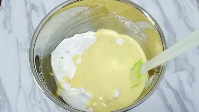 南瓜戚风蛋糕,将混合好的蛋黄糊全部倒入蛋白中，上下翻拌均匀，像炒菜一样的手法