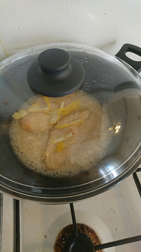柠檬鸡胸肉,盖上锅盖小火煮三分钟，然后翻面把之前准备好的柠檬皮洒在鸡肉上面继续煮，热量会让柠檬散发出香气，加上我们不需要着急收汁，所以最好盖上锅盖慢煮