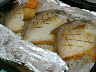 香烤平鱼,鱼入味后，放入铺上锡纸的烤盘中，刷上一层食用油，并用锡纸将鱼尾盖上～