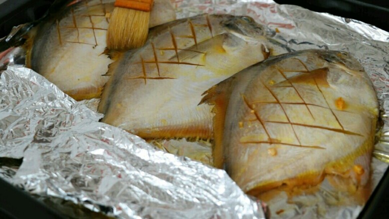 香烤平鱼,鱼入味后，放入铺上锡纸的烤盘中，刷上一层食用油，并用锡纸将鱼尾盖上～