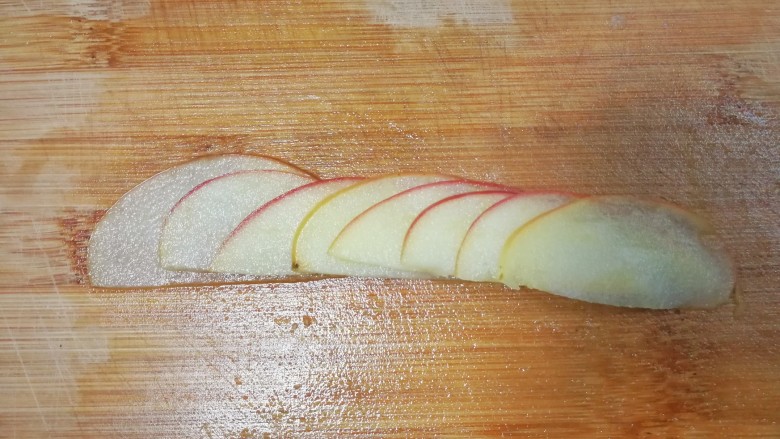 美丽早餐之果酱苹果花土司,取八个苹果片，横向排开，慢慢的把他们卷起来，呈玫瑰花的形状。