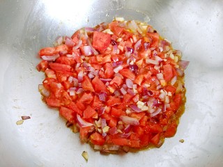 百搭西红柿+家庭简易版披萨酱,加入西红柿丁继续翻炒均匀。