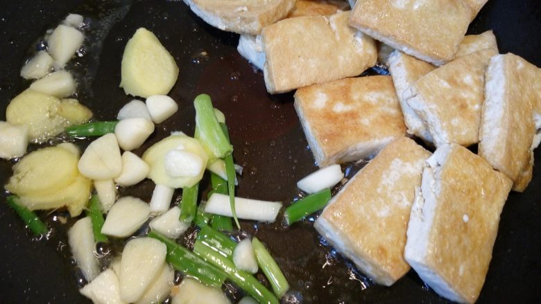 菌茹烩豆腐,把豆腐推到一边，倒入葱姜蒜等调料。