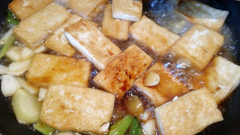 菌茹烩豆腐,倒入半碗高汤，大火烧开，加入一小勺盐，小火焖煮5分钟让豆腐入味。
