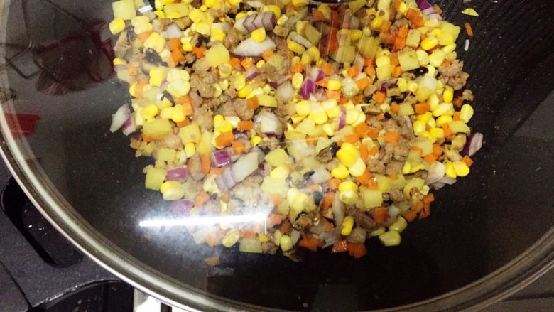 土豆藜麦炒五色丁,翻炒均匀，盖上锅焖煮2分钟