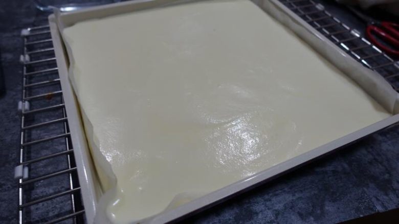 奶牛蛋糕卷（后蛋法）,借用刮板刮平表面，再轻震几下，去除表面大气泡。