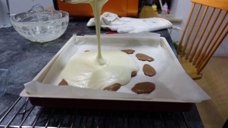 奶牛蛋糕卷（后蛋法）,放入烤箱1分钟左右，表面凝固以后可以拿出来，面糊从高处倒入垫了烘焙纸（或者硅胶垫）的28*28金盘中，