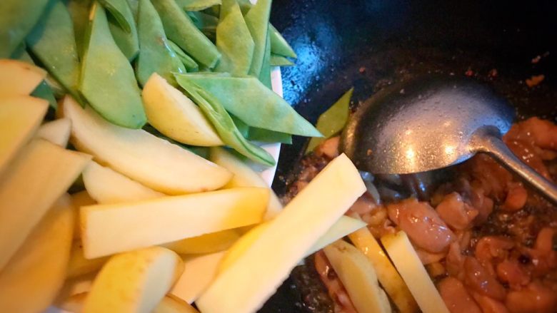 香辣焖面,鸡腿肉变色，即可放入扁豆土豆，翻炒均匀。