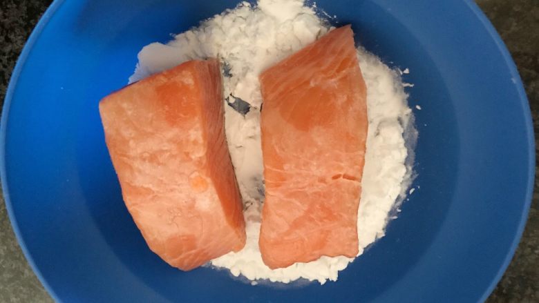 芝麻香煎三文鱼,先将三文鱼带皮的一面在淀粉碗里抹一下，