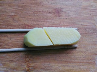 孜然土豆塔,取一双不用的筷子，放在土豆块两边对齐，然后在上面切均匀的斜刀；（借用筷子辅助，土豆就不会切断了）
