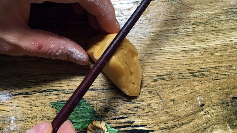 南瓜花卷,取一个三角朝上，用筷子在中间按在一下