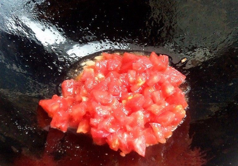 百塔西红柿：海鲜大红虾意面,加入番茄丁继续炒。