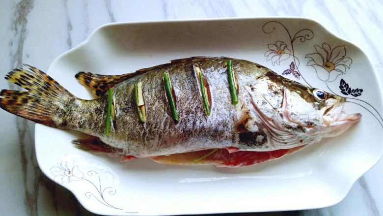 #味道鲜美的#清蒸桂鱼,再鱼背划痕处摆放上葱段。