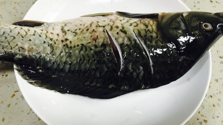 美味的红烧鱼,正背面划两刀，将姜片塞进去划开的鱼缝里。