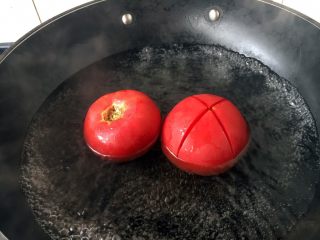 孩子爱吃的西红柿鸡蛋打卤面,水开后放入西红柿，正反两面都要烫30秒左右，这样容易剥皮。