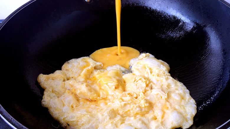 孩子爱吃的西红柿鸡蛋打卤面,提前打散鸡蛋，锅里放适量的油，鸡蛋液成型后，用铲子把鸡蛋滑散成碎片状。