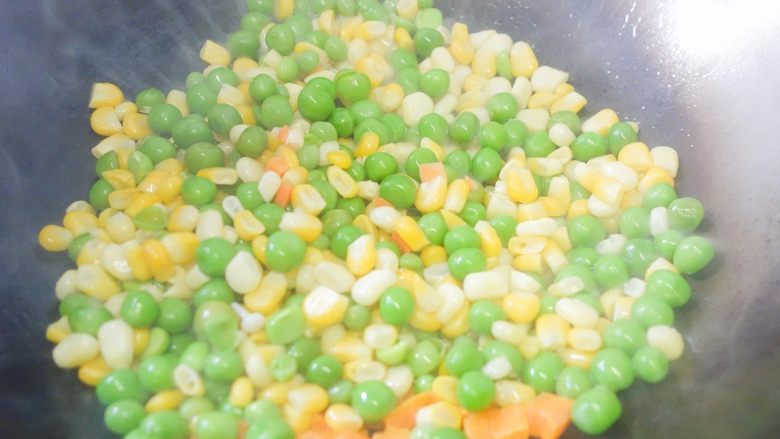 这样吃蔬菜孩子肯定爱 田园蔬菜,热锅冷油倒入胡萝卜翻炒一会再加入青豆、玉米
