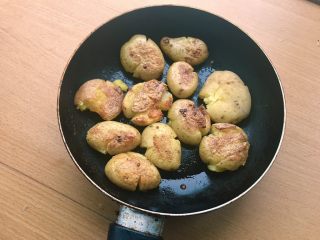 椒盐土豆,小火煎至一面呈现金黄虎斑，翻面。煎的时候可以轻轻用铲子压一压，让皮入油，更加酥脆。