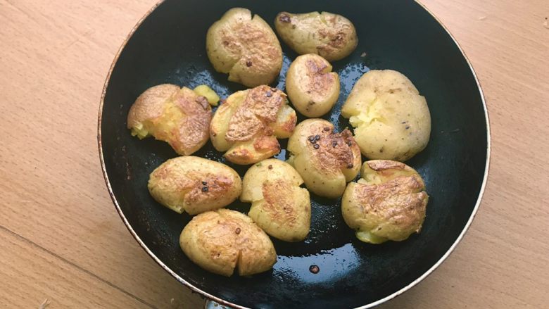 椒盐土豆,小火煎至一面呈现金黄虎斑，翻面。煎的时候可以轻轻用铲子压一压，让皮入油，更加酥脆。