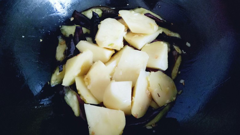 土豆茄子白菜煲,倒入土豆继续翻炒。